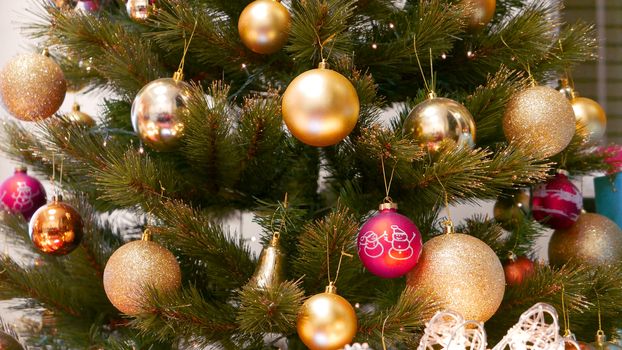 Indoor Christmas tree closeup with decoration golden and red balls