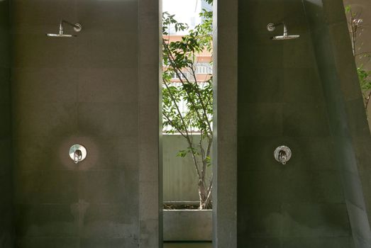 Two shower heads in the outdoor swimming pool bathroom