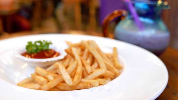 french fries fast food on white dish on the table with ketchup