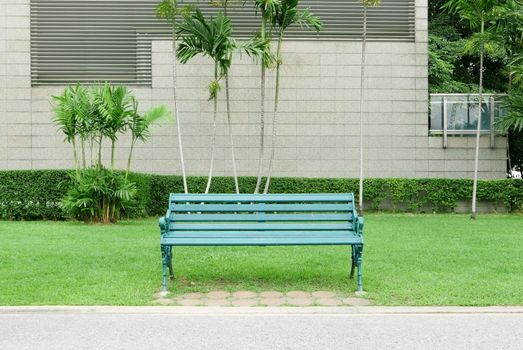 Classic green bench with grass in the public park