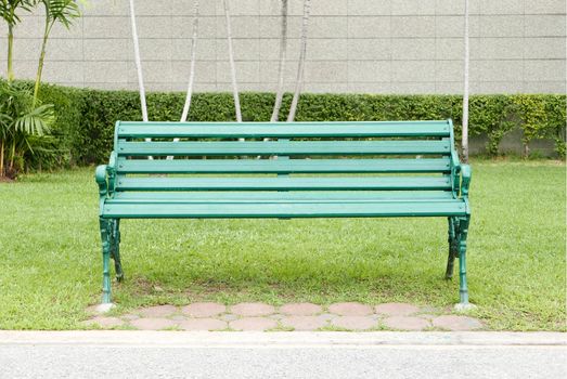 Classic green bench with grass in the public park