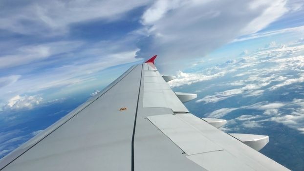 Blue sky cloudscape background and the wing of airplane 