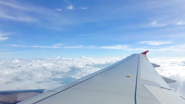 Blue sky cloudscape background and the wing of airplane 