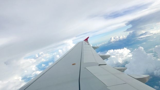 Blue sky cloudscape background and the wing of airplane 