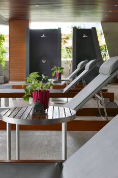 Vertical suntan chair, small table, decoration near the swimming pool