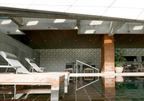 The swimming pool in the hotel with reflection of the suntan chair