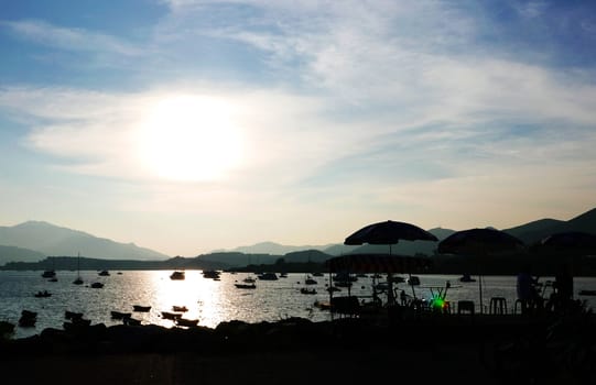 The Silhouette of fishing boat on the lake and the blue sky