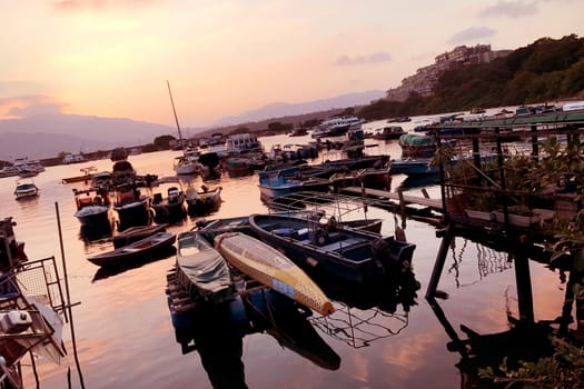 Fishing boat in wharf and the gradient orange sky at sunset