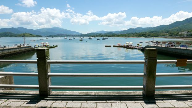 Boats, pier, lake and the white cloud in the sunny day