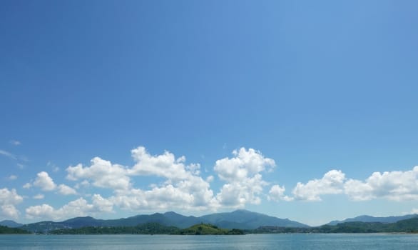 Green mountain, lake, blue sky and the white cloud