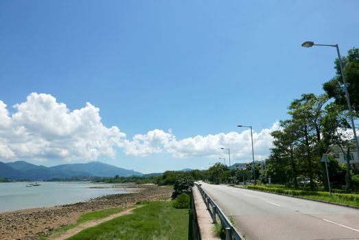 Sailboat, lake, road in the countryside with blue clean sky