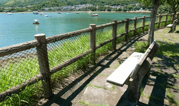 Outdoor wooden fence, bench, mountain, boats and tree