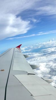 Blue sky cloudscape background and the wing of airplane 