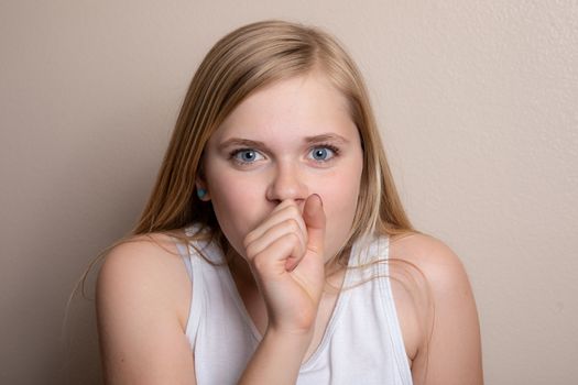 girl who can be sick or with allergies is coughing into her hand