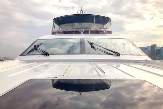 The front window of white yacht and the cloud reflection