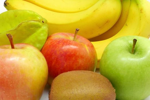 bananas, green, red apple, carambola, kiwi fruits on white background
