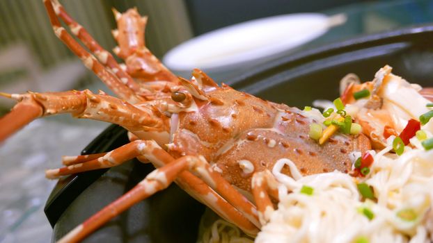 Homemade lobster noodles with cheese in the black bowl