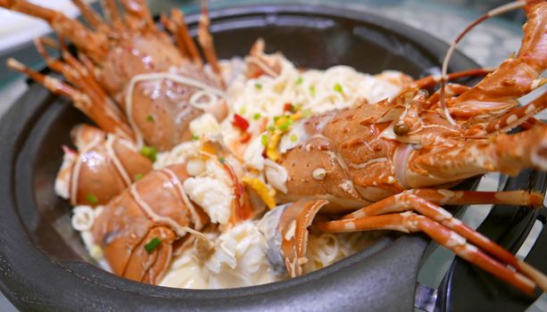 Homemade lobster noodles with cheese in the black bowl