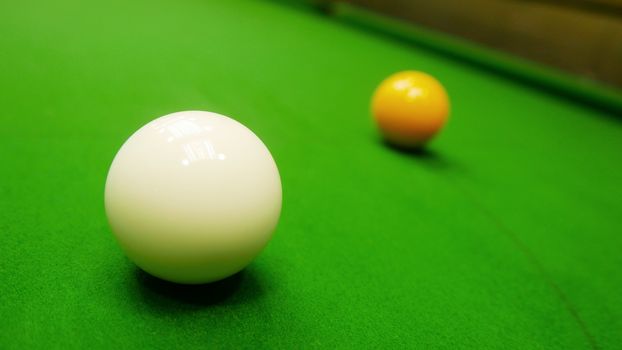 snooker white and yellow balls on green table