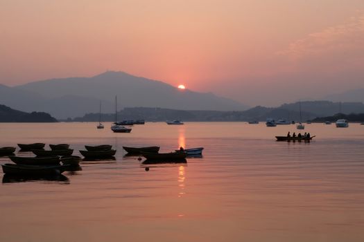 recreational boats on the lake at sunset