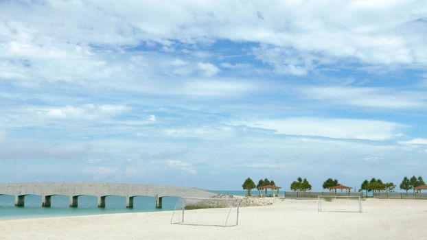 soccer goal net ,blue sky, tree and beach