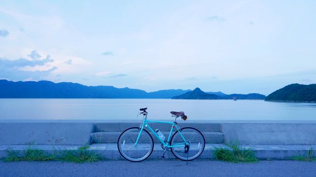 Bicycle retro style with leather seat and bagBicycle, road, cloud and lake in the early evening