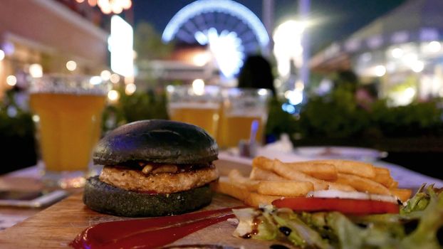 Black burger, fries and drink meal dinner set at night