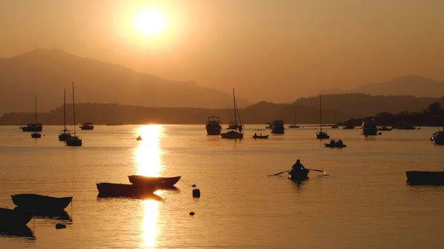 Some shadow of sailboats, fishing and creational boats before sunset