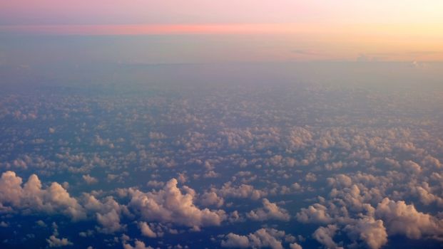 white fluffy clouds and the sun at sunset