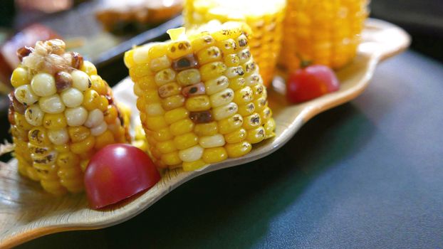 Corns, small tomato and vegetables are on the dish
