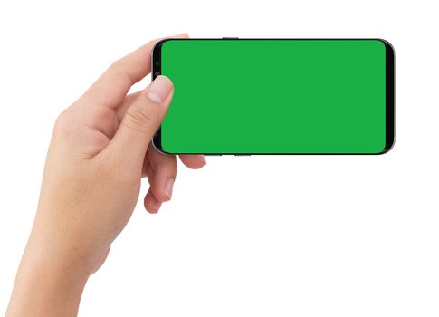 Isolated human left hand holding black mobile smart phone with green screen for video production
