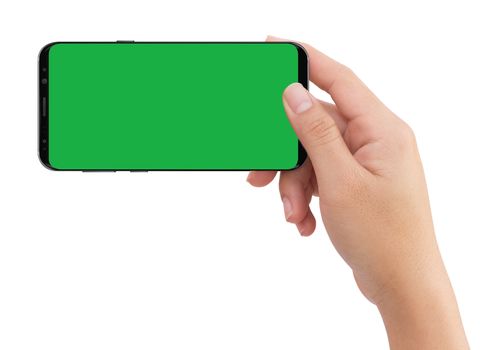 Isolated human right hand holding black mobile smart phone with green screen for video production