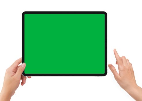 Isolated human left hand holding vertical black tablet media device with green screen for video production