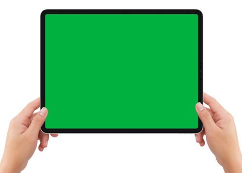 Isolated human left hand holding vertical black tablet media device with green screen for video production