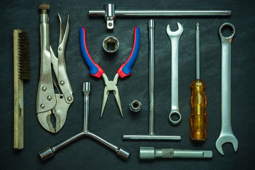 Set of many hand tools on cement floor. Top view of craftsman tool on black background. Concept of technician or engineer.