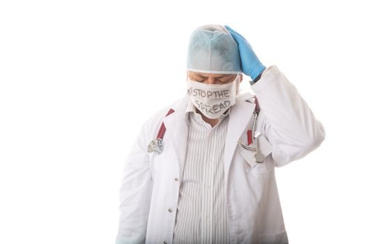 Anguished overworked and overwhelmed doctor with head in hands during infecious pandemic