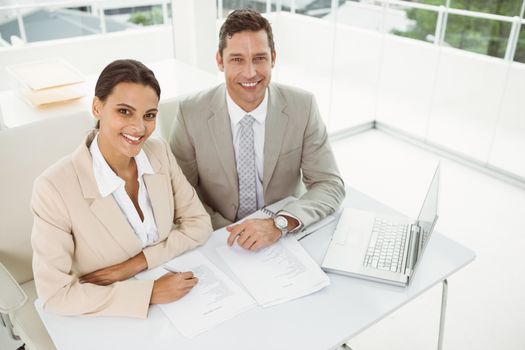 Portrait of two young business people in meeting at office