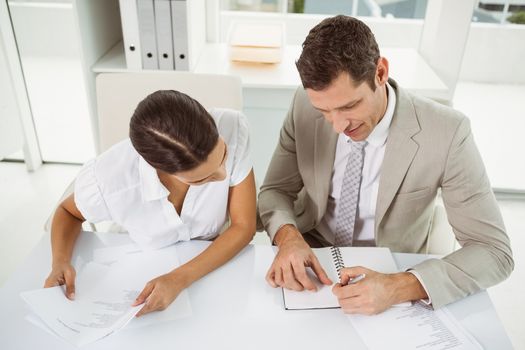 Two young business people with diary in the office