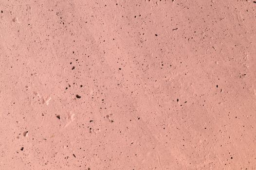 The pink concrete wall. The wall is textured.