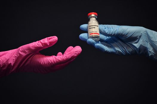 Woman Hand With Glove Giving Coronavirus Vaccine to Other Hand