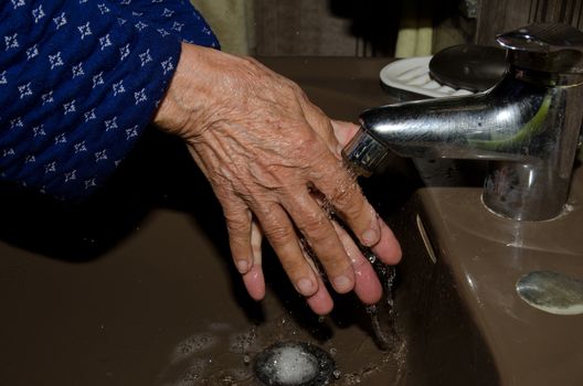 Older woman washing her hands to prevent coronavirus, covid-19. Las Palmas de Gran Canaria. Las Palmas. Gran Canaria. Spain.