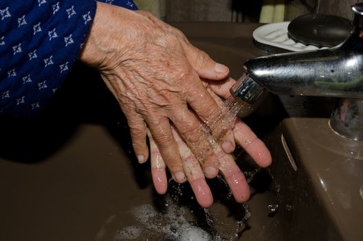Older woman washing her hands to prevent coronavirus, covid-19. Las Palmas de Gran Canaria. Las Palmas. Gran Canaria. Spain.