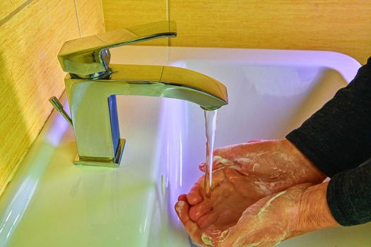 Hands hygiene prevention of coronavirus virus outbreak. Man rubbing his hands. Coronavirus pandemic prevention wash hands with soap  using warm water. Wash nails and fingers  frequently or use hand sanitizer gel