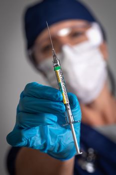 Doctor or Nurse Holding Medical Syringe with Coronavirus COVID-19 Vaccine Label.