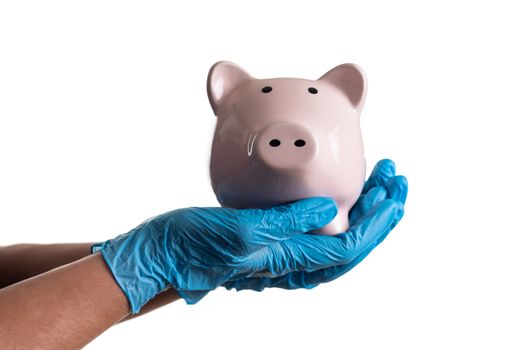 Doctor or Nurse Wearing Surgical Gloves Holding Piggy Bank Isolated on White.