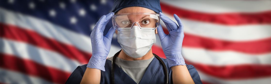 Doctor or Nurse Wearing Medical Personal Protective Equipment (PPE) Against The American Flag Banner.
