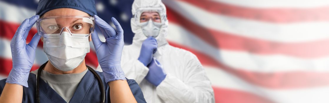 Doctors or Nurses Wearing Medical Personal Protective Equipment (PPE) Against The American Flag Banner.