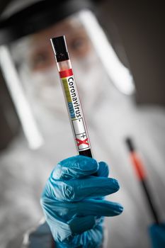 Female Doctor or Nurse Holding Test Tube of Blood Labeled Positive for Coronavirus COVID-19 Disease.