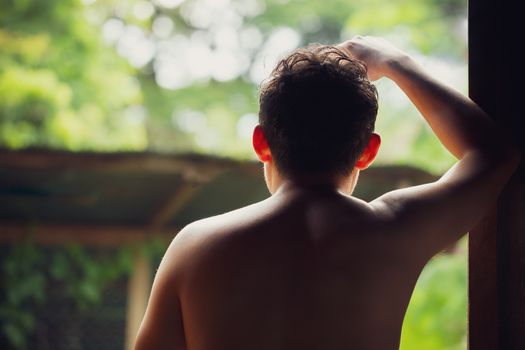 Depressed man standing beside windows and thinking. Closeup and copy space for text.