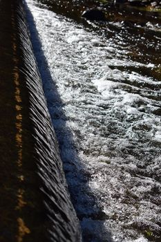 A small waterfall flowing off the side of the road